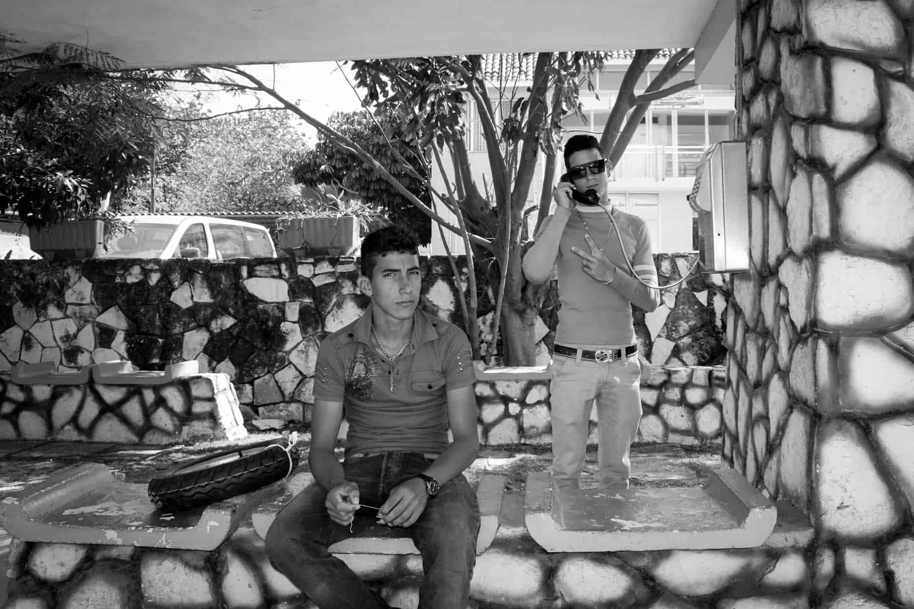 Black and White photo of two Cuban teenages hanging out at a bus stop in Varadero, Cuba
