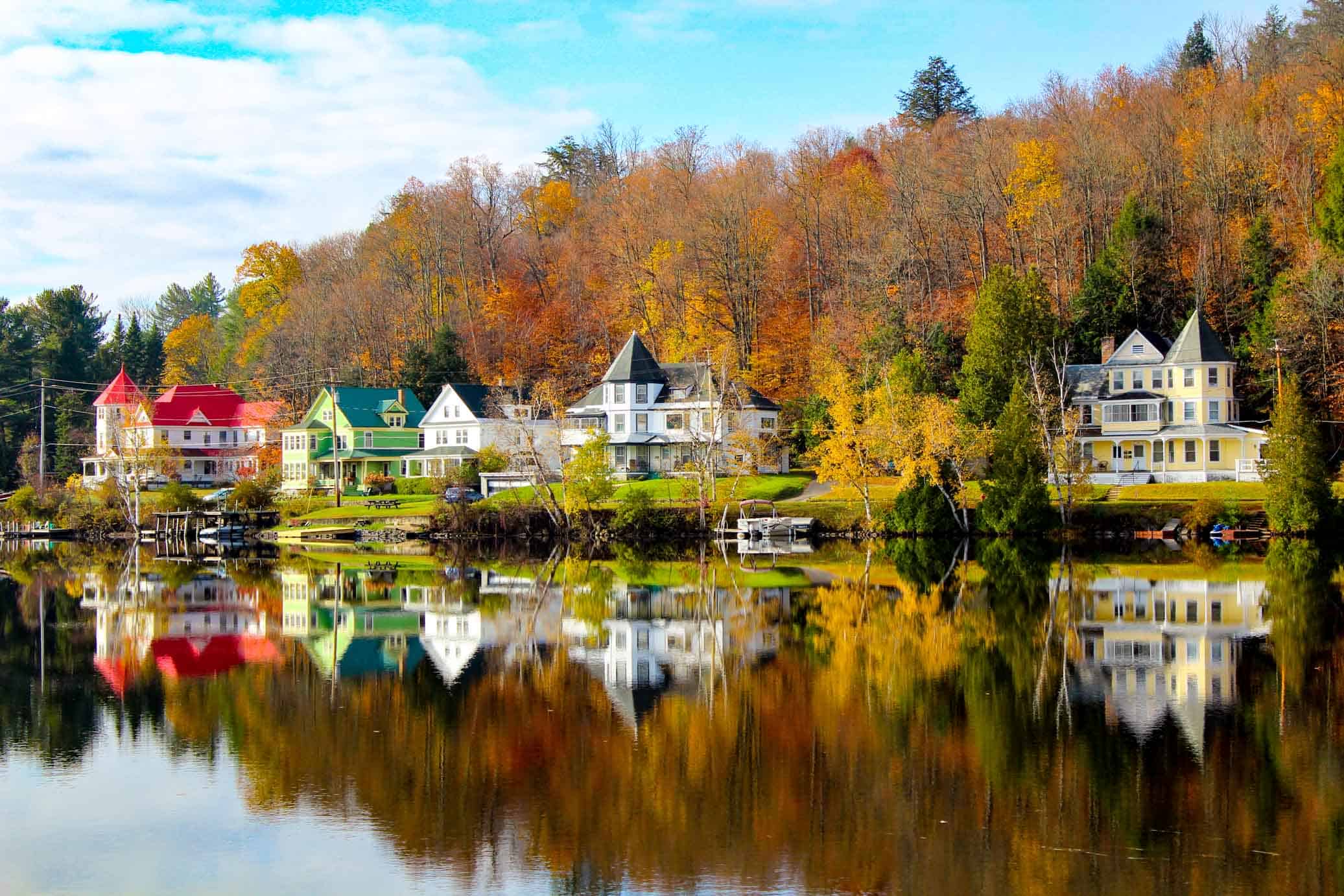 Beautiful large homes reflecting in the water on a colourful fall day